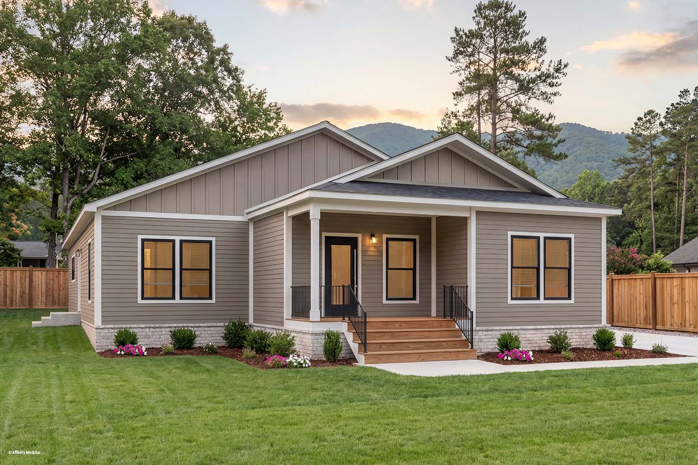 Single-story modern modular home with a front porch, neatly landscaped yard, and trees in the background.